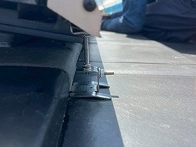 西条市で、太陽光パネルの鳩対策工事。バードブロッカー本体をしっかり固定するための専用金具を取り付けます。